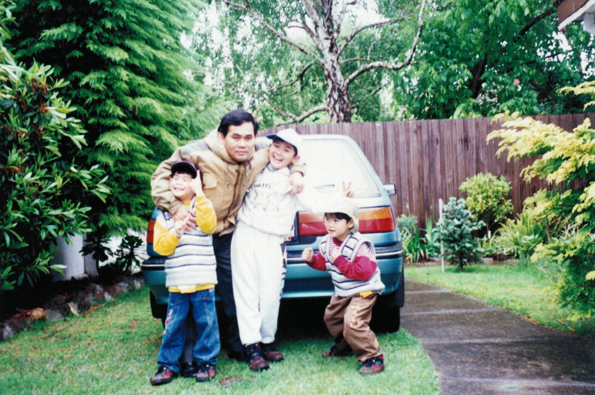 Family of four standing in front of a van in a garden setting